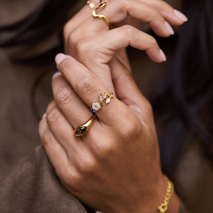 Anillo dorado con flor blanca de cristal