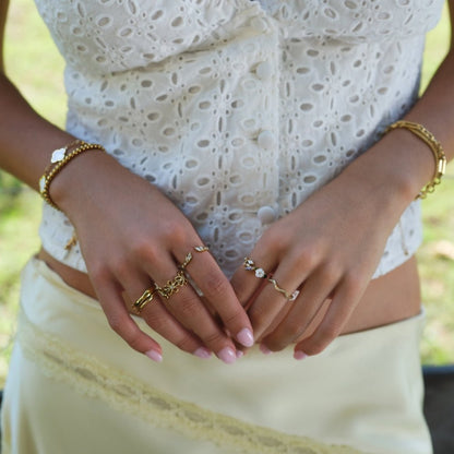 Anillo dorado con flor blanca de cristal
