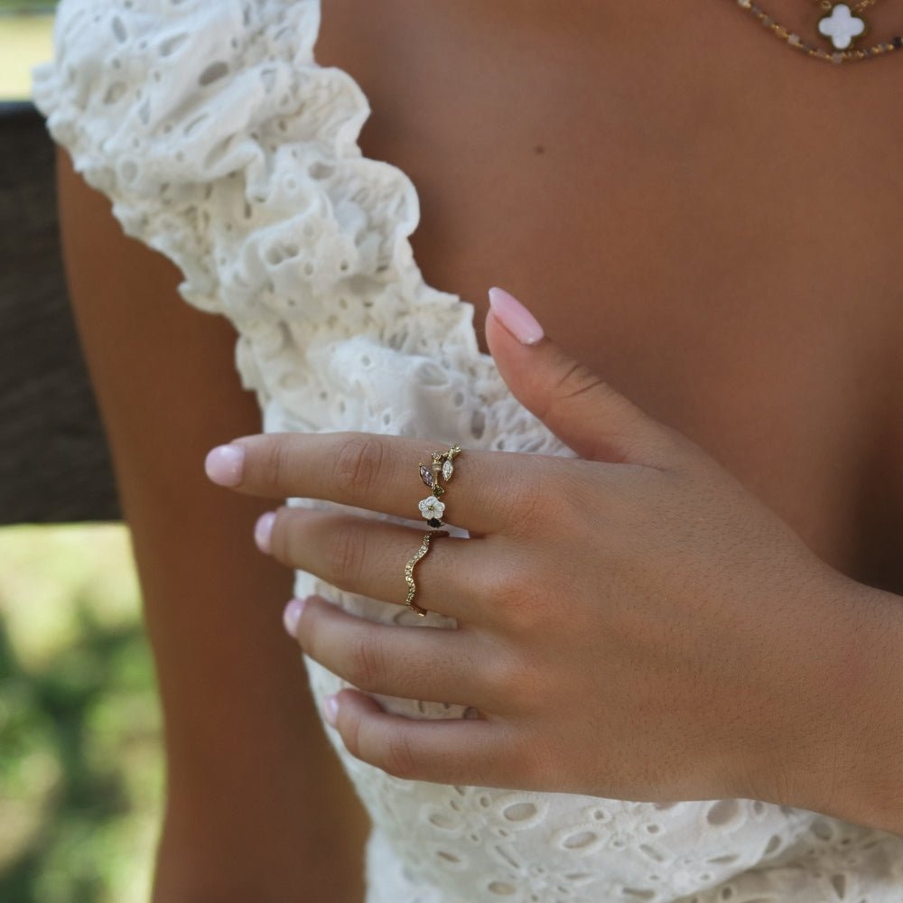 Anillo dorado con flor blanca de cristal