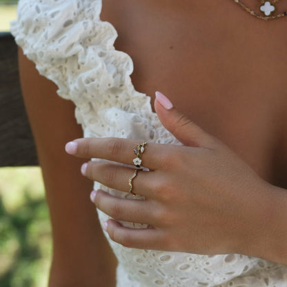 Anillo dorado con flor blanca de cristal